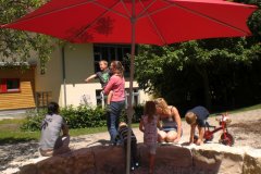 Knallroter Sonnenschutz: Der neue Schirm im Sandkasten